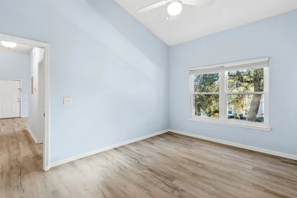 an empty room with wooden floor and windows