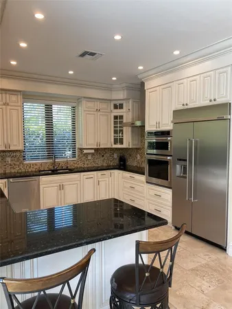 a large kitchen with kitchen island a large window