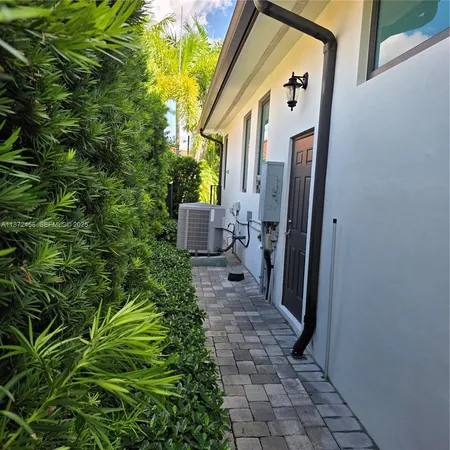 a view of a pathway of a house with potted plants