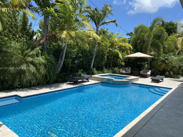 a view of swimming pool with lawn chair under an umbrella
