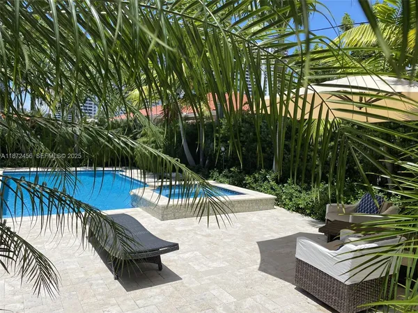 a view of swimming pool with chairs and wooden fence