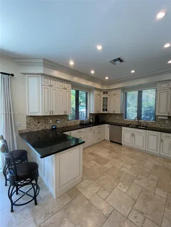 a open kitchen with stainless steel appliances granite countertop a stove and a sink