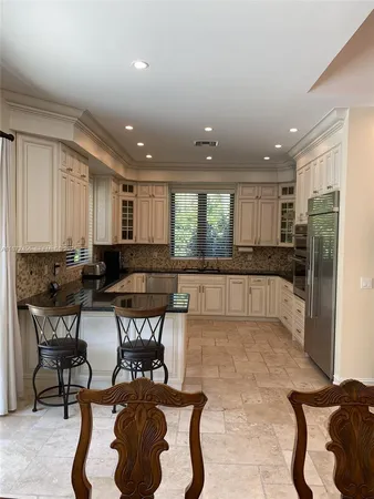 a kitchen with a dining table chairs and window