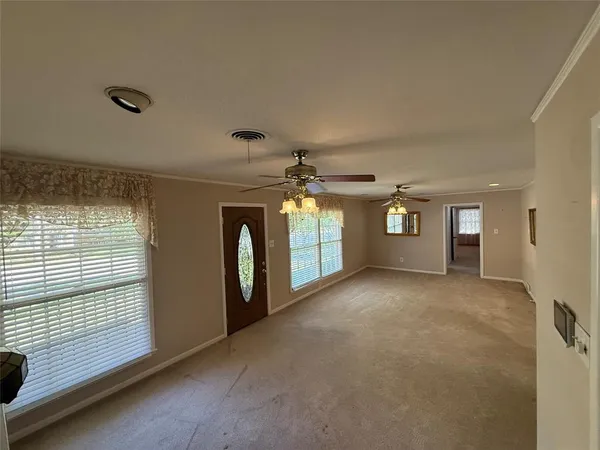 a view of a livingroom with a ceiling fan and window
