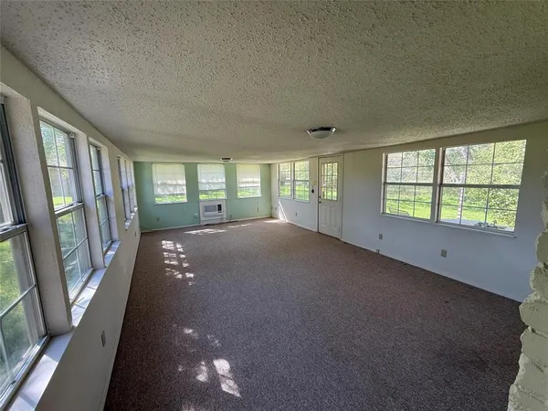 a view of an empty room with a fireplace and a window