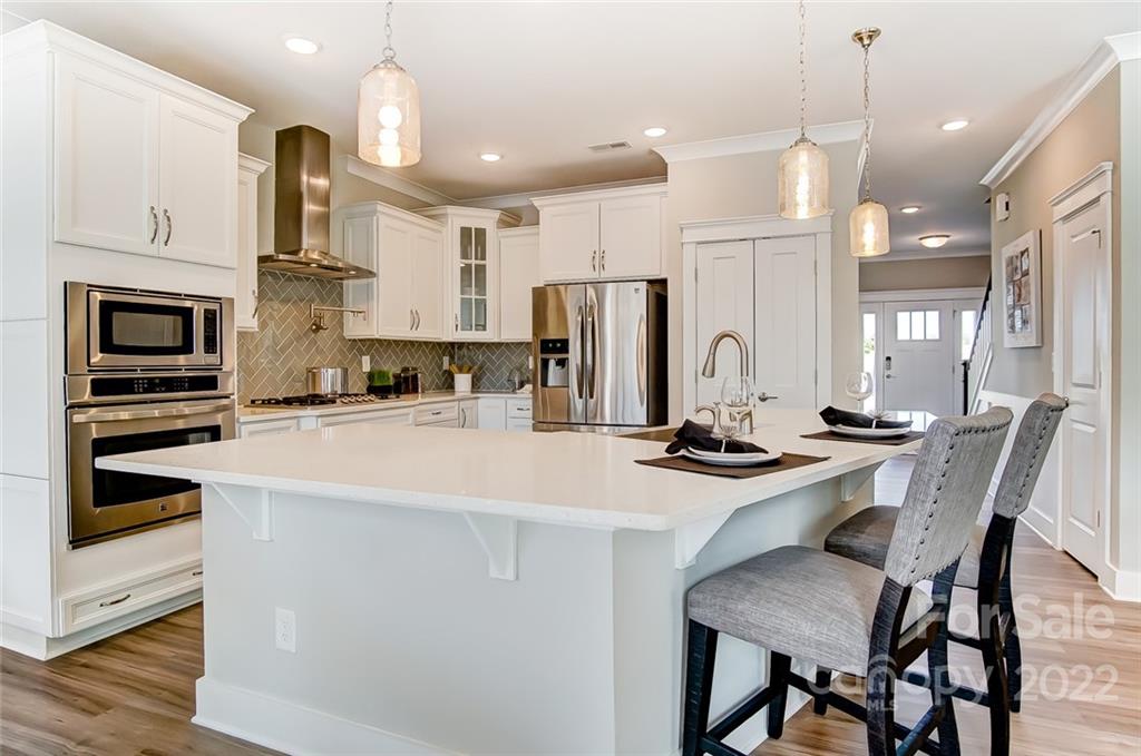 1006 Baldwin Drive Lancaster, SC 29720 - Photo 16 of 48 a kitchen with stainless steel appliances kitchen island granite countertop a stove a sink a refrigerator and white cabinets with wooden floor