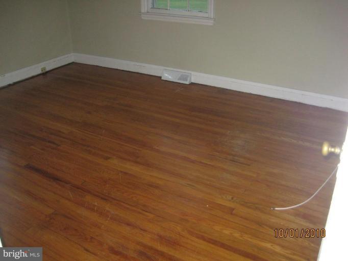 612 Reckord Road Fallston, MD 21047 - Photo 4 of 8 an empty room with wooden floor and windows
