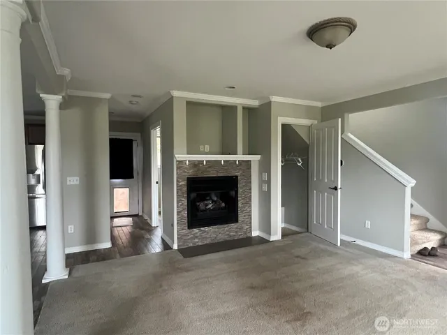 a view of an empty room with a fireplace and a window