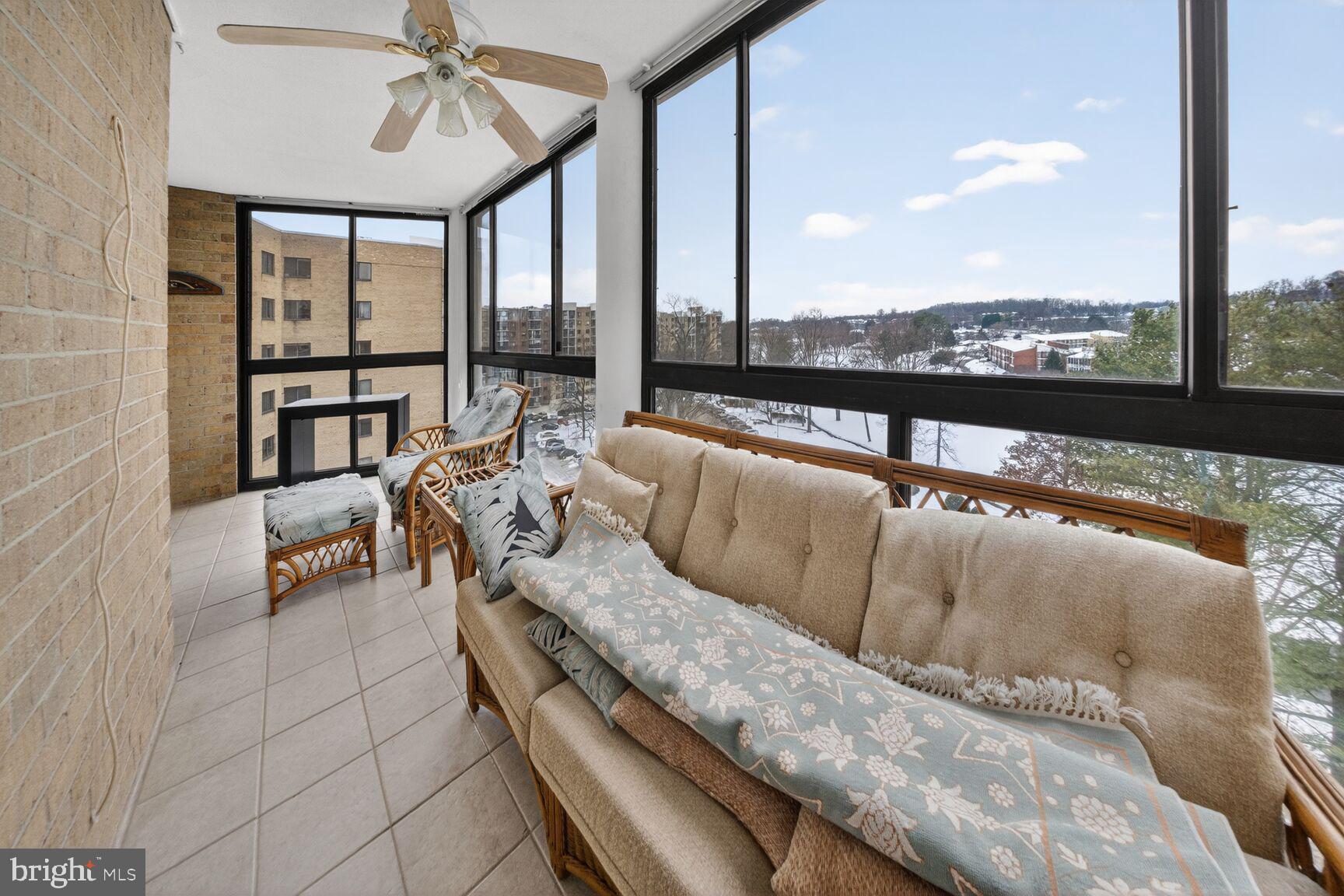 15115 Interlachen Drive, Unit 3812 Silver Spring, MD 20906 - Photo 32 of 46 a living room with furniture and a floor to ceiling window