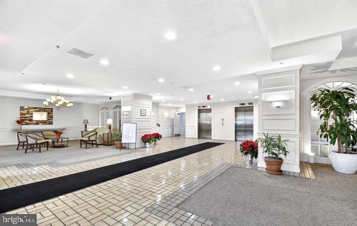 15115 Interlachen Drive, Unit 3812 Silver Spring, MD 20906 - Photo 5 of 46 a lobby with furniture and potted plants