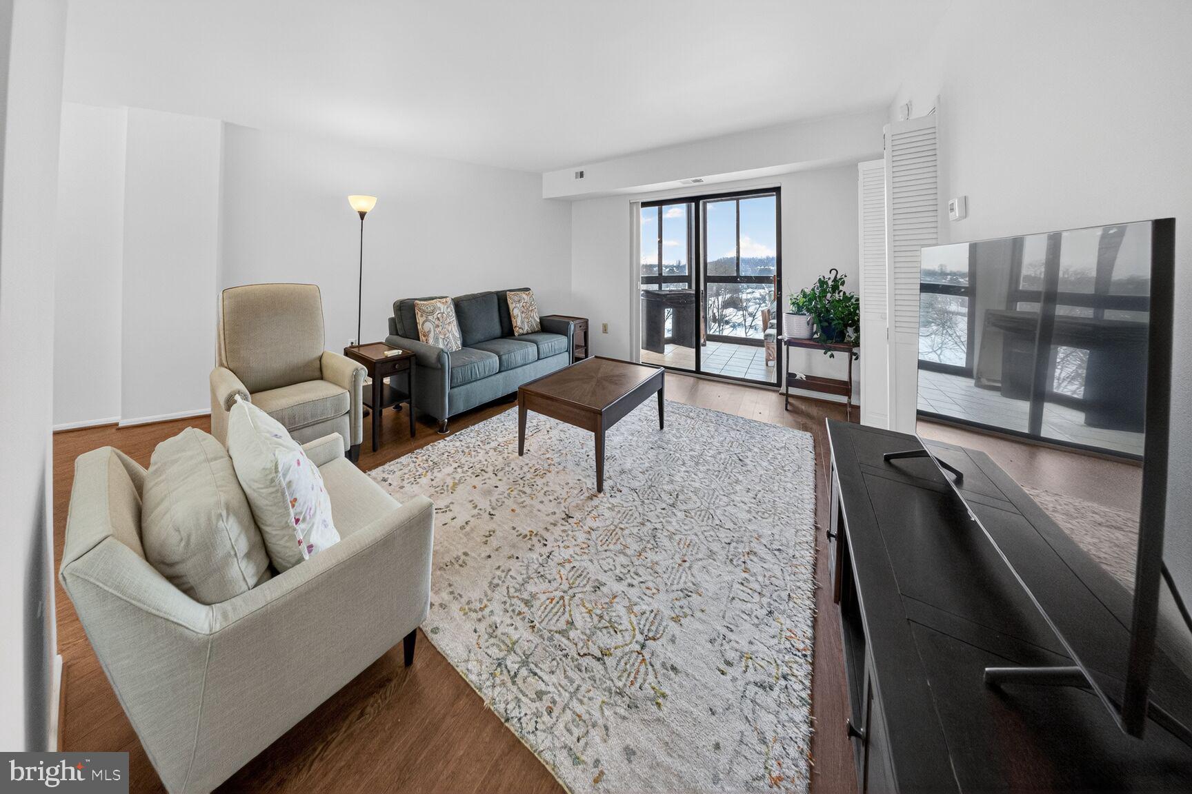 15115 Interlachen Drive, Unit 3812 Silver Spring, MD 20906 - Photo 8 of 46 a living room with furniture and a floor to ceiling window