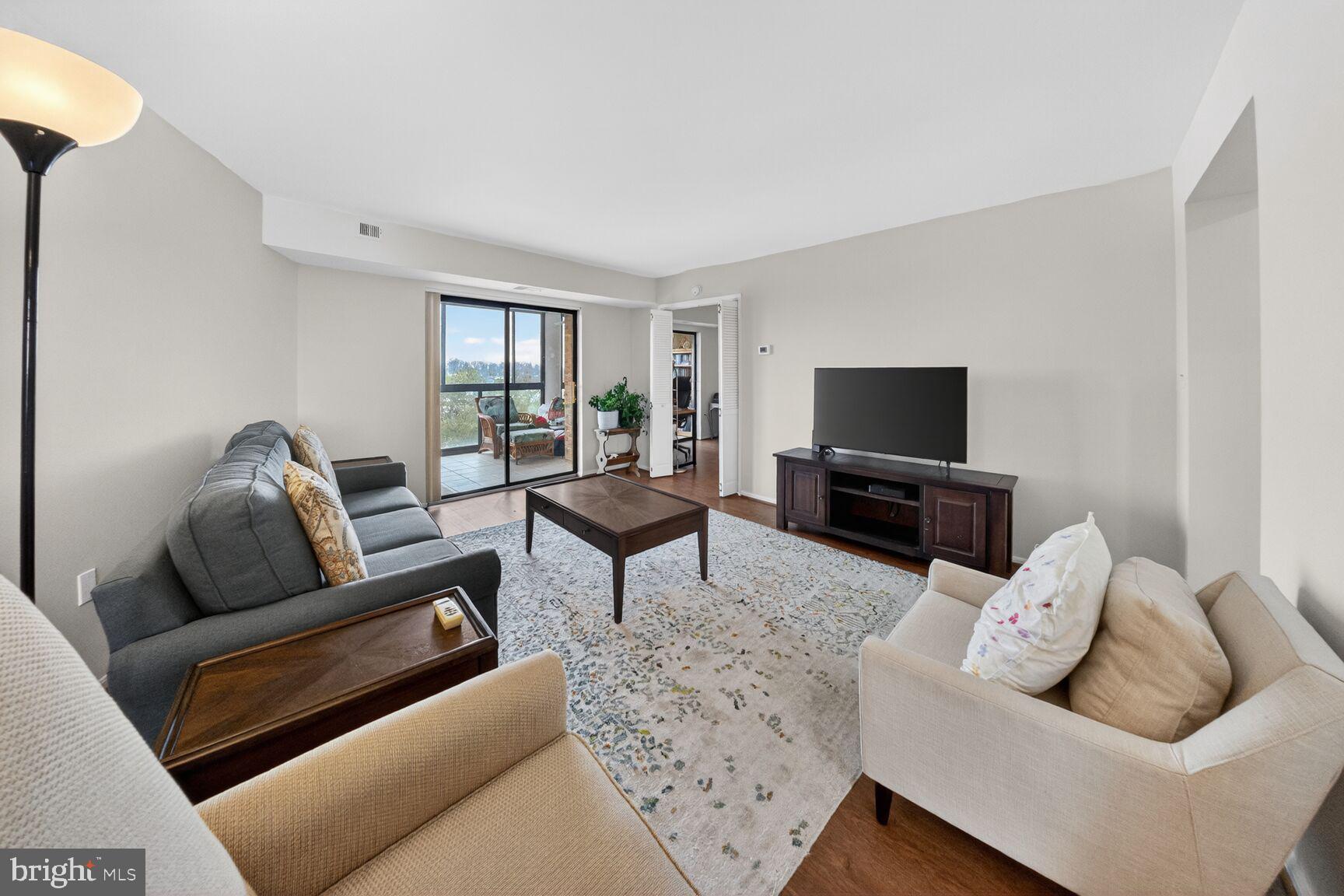 15115 Interlachen Drive, Unit 3812 Silver Spring, MD 20906 - Photo 9 of 46 a living room with furniture and a flat screen tv