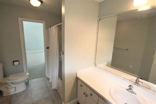 a bathroom with a sink and mirror with toilet
