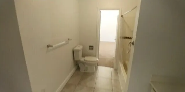 a bathroom with a granite countertop toilet and a shower