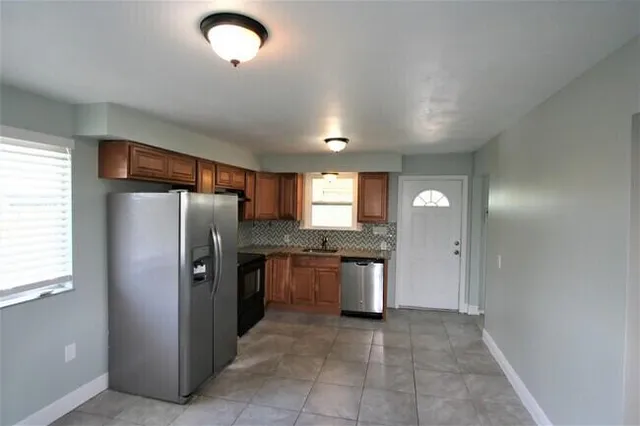 a kitchen with stainless steel appliances granite countertop a refrigerator and a sink