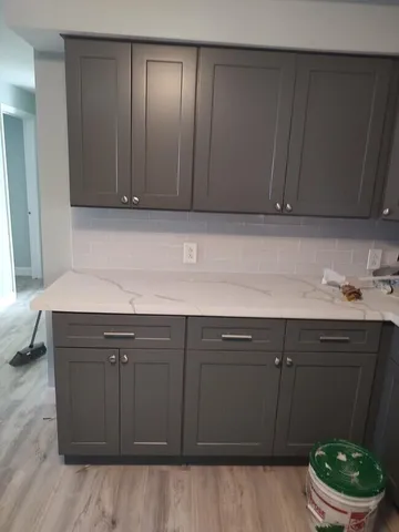 a room with a sink cabinets and chair
