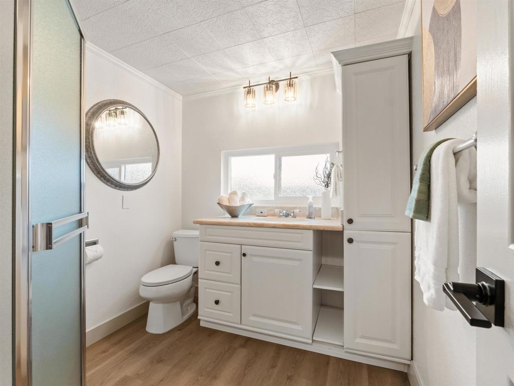 13737 Temple Street Poway, CA 92064 - Photo 28 of 38 a bathroom with a toilet a sink a mirror and a window