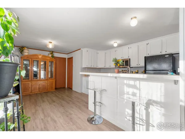 a kitchen with stainless steel appliances kitchen island granite countertop a refrigerator a stove top oven a sink with island and chairs