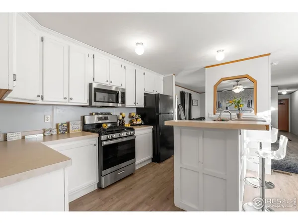 a kitchen with kitchen island granite countertop a stove top oven microwave and cabinets