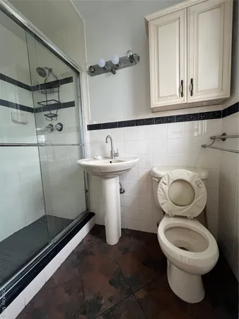 a bathroom with a toilet a sink and mirror