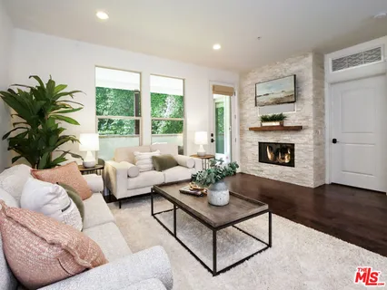 a living room with furniture fireplace and a large window