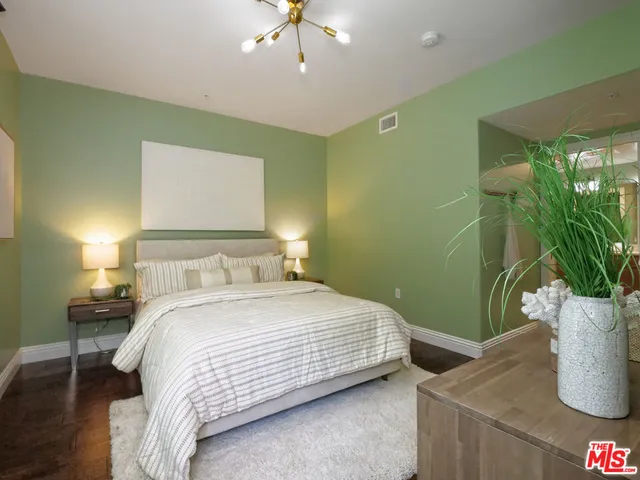 a bedroom with a bed and a potted plant