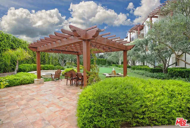 a view of a patio with table and chairs under an umbrella