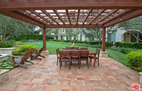a view of a patio with table and chairs potted plants with large tree