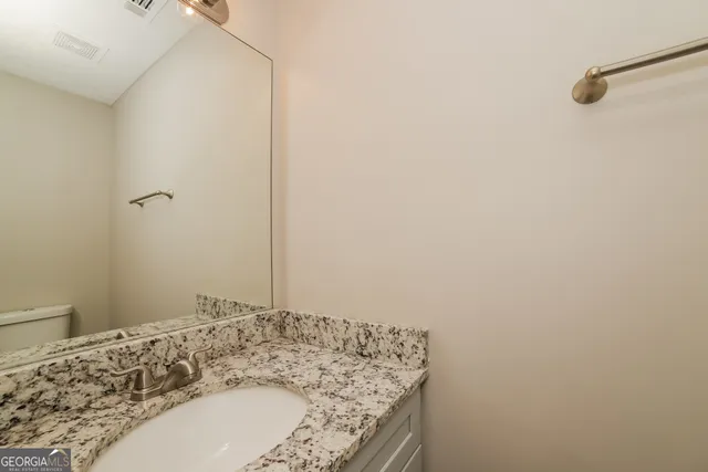 a bathroom with a granite countertop sink and a mirror