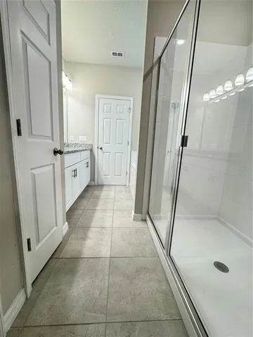 a spacious bathroom with a granite countertop sink and a bathtub