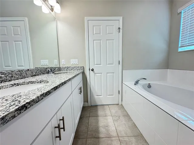 a bathroom with a granite countertop toilet a sink and a bathtub