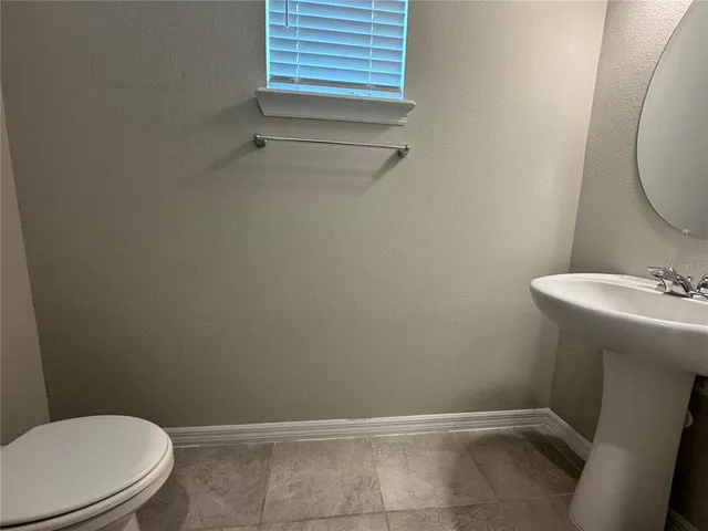 a view of a patio with lawn chairs and a floor to ceiling window
