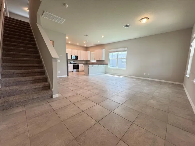 a view of a livingroom with entryway and stairs