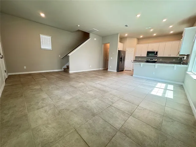 a view of an empty room and kitchen stove kitchen island