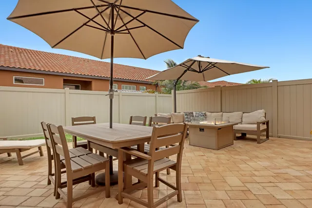 a view of a patio with table and chairs under an umbrella