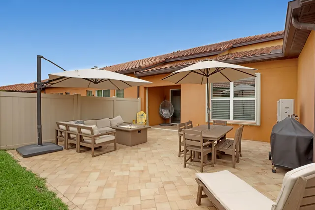 a view of a patio with table and chairs under an umbrella