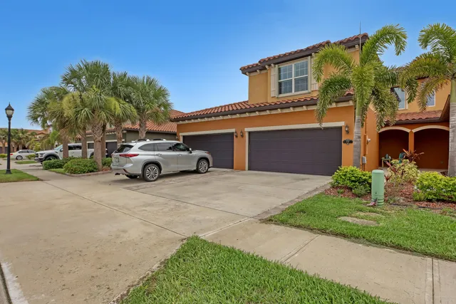 a front view of a house with a garden and parking