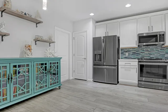 a kitchen with stainless steel appliances granite countertop a refrigerator and a stove top oven