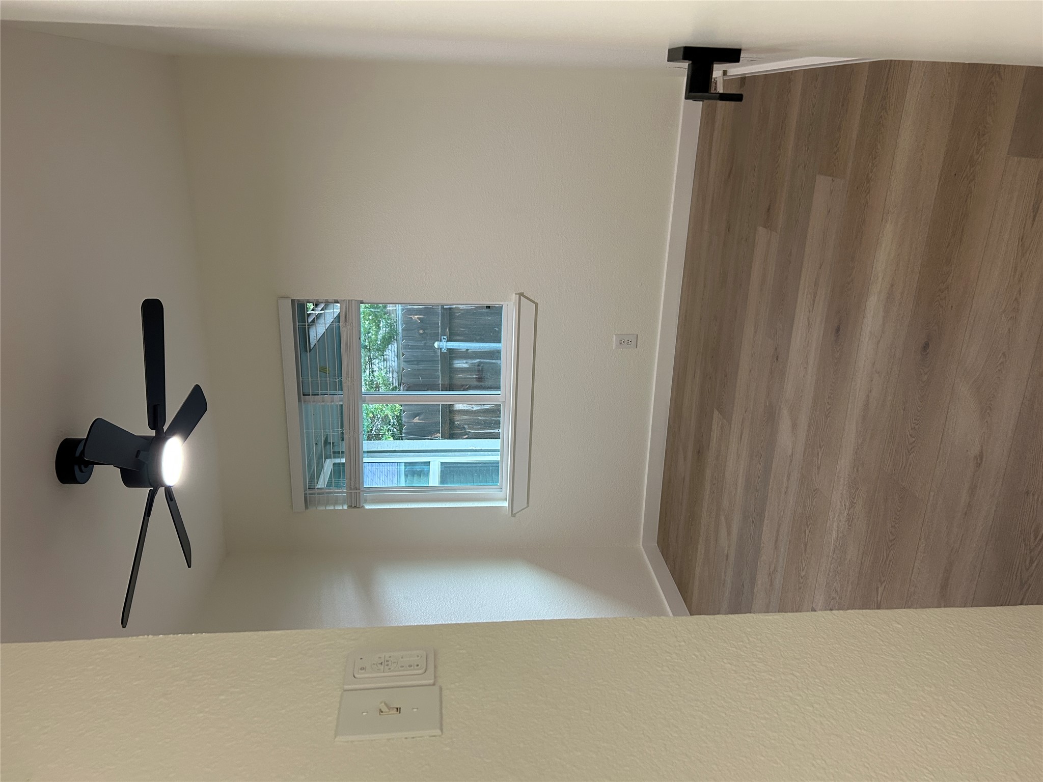 6502 South 1st Street, Unit 101 Austin, TX 78745 - Photo 11 of 12 Room featuring wood-finish flooring, a contemporary ceiling fan with integrated lighting, and a window with blinds
