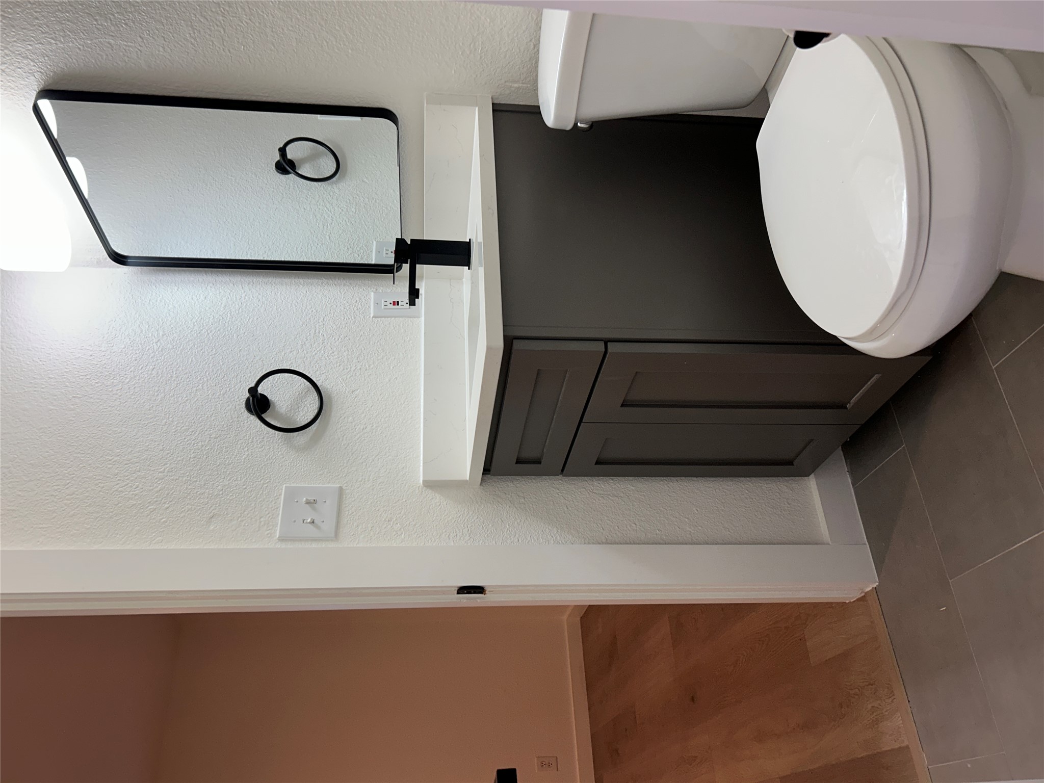 6502 South 1st Street, Unit 101 Austin, TX 78745 - Photo 7 of 12 Bathroom vanity featuring a grey cabinet, a white countertop, a black framed mirror, and a matte black faucet
