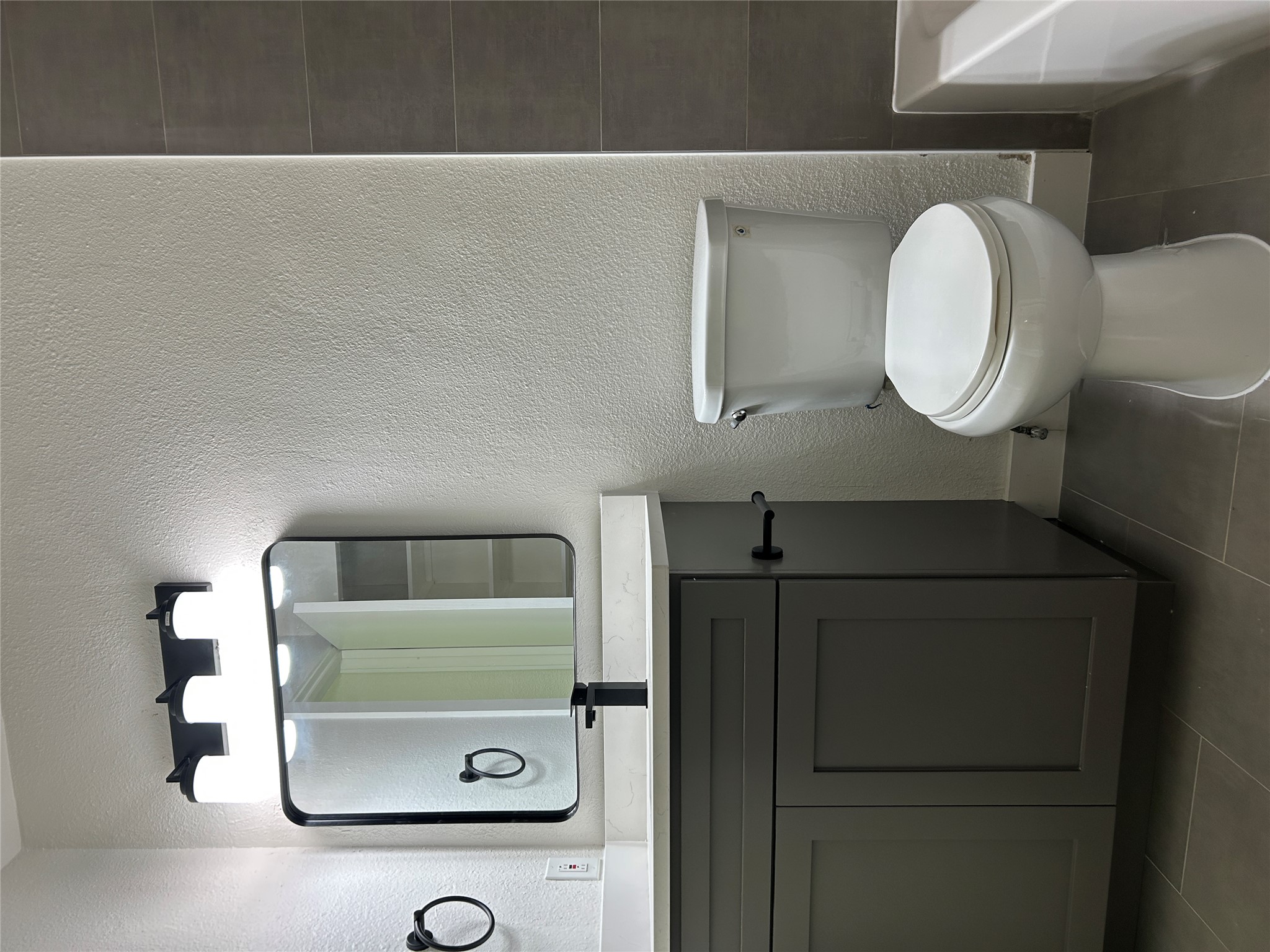 6502 South 1st Street, Unit 101 Austin, TX 78745 - Photo 8 of 12 Bathroom featuring a gray shaker-style vanity with white countertop, rectangular mirror with black frame, and a three-light vanity fixture