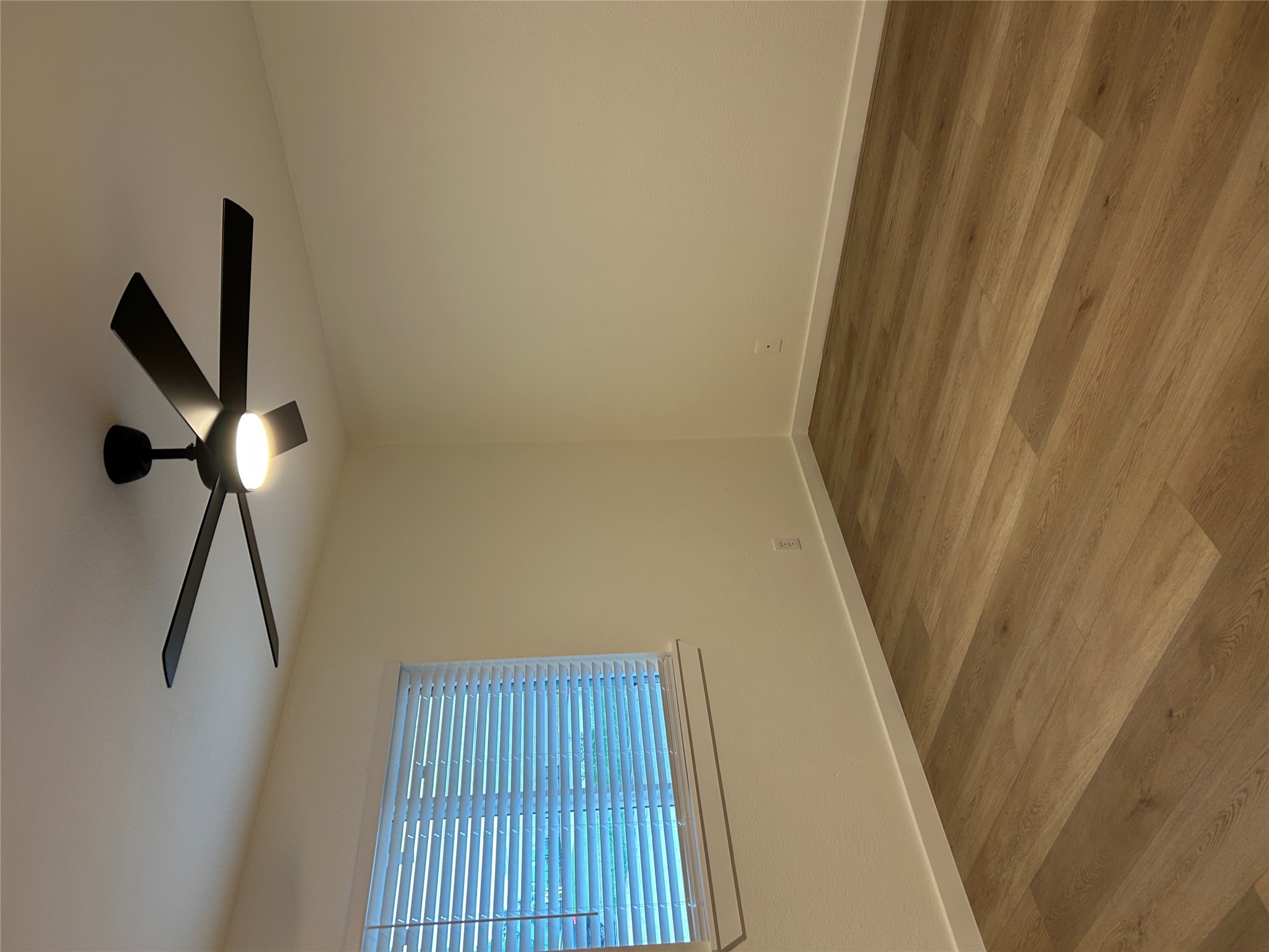 6502 South 1st Street, Unit 101 Austin, TX 78745 - Photo 9 of 12 Spacious room featuring wood-finish flooring and a modern black ceiling fan with integrated lighting