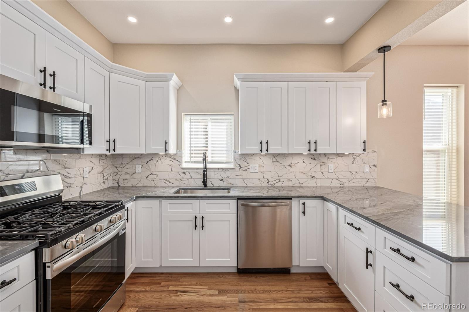 3854 Cook Street Denver, CO 80205 - Photo 12 of 42 a kitchen with granite countertop a sink stove and cabinets