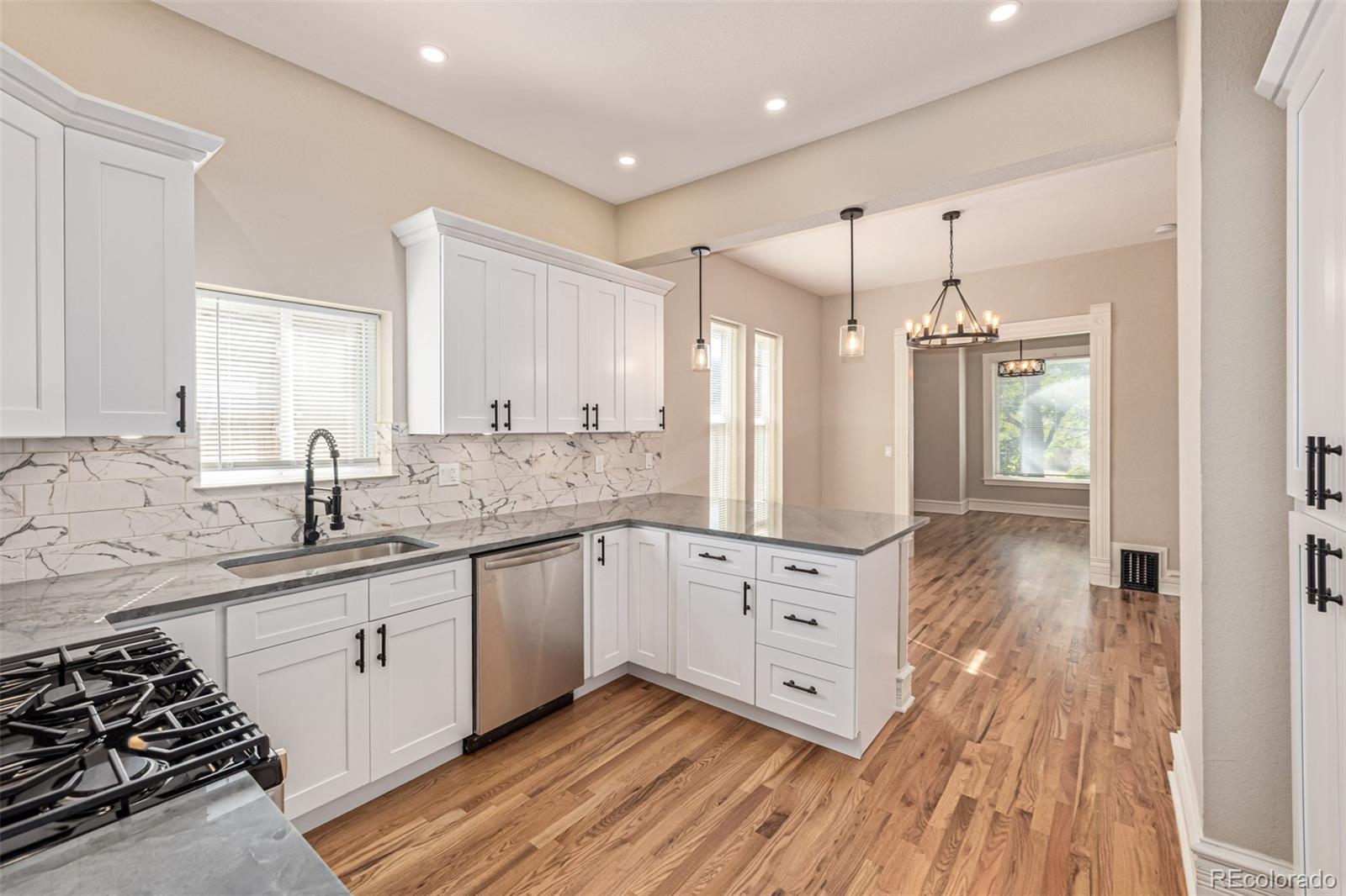 3854 Cook Street Denver, CO 80205 - Photo 13 of 42 a kitchen with granite countertop a sink cabinets and wooden floor