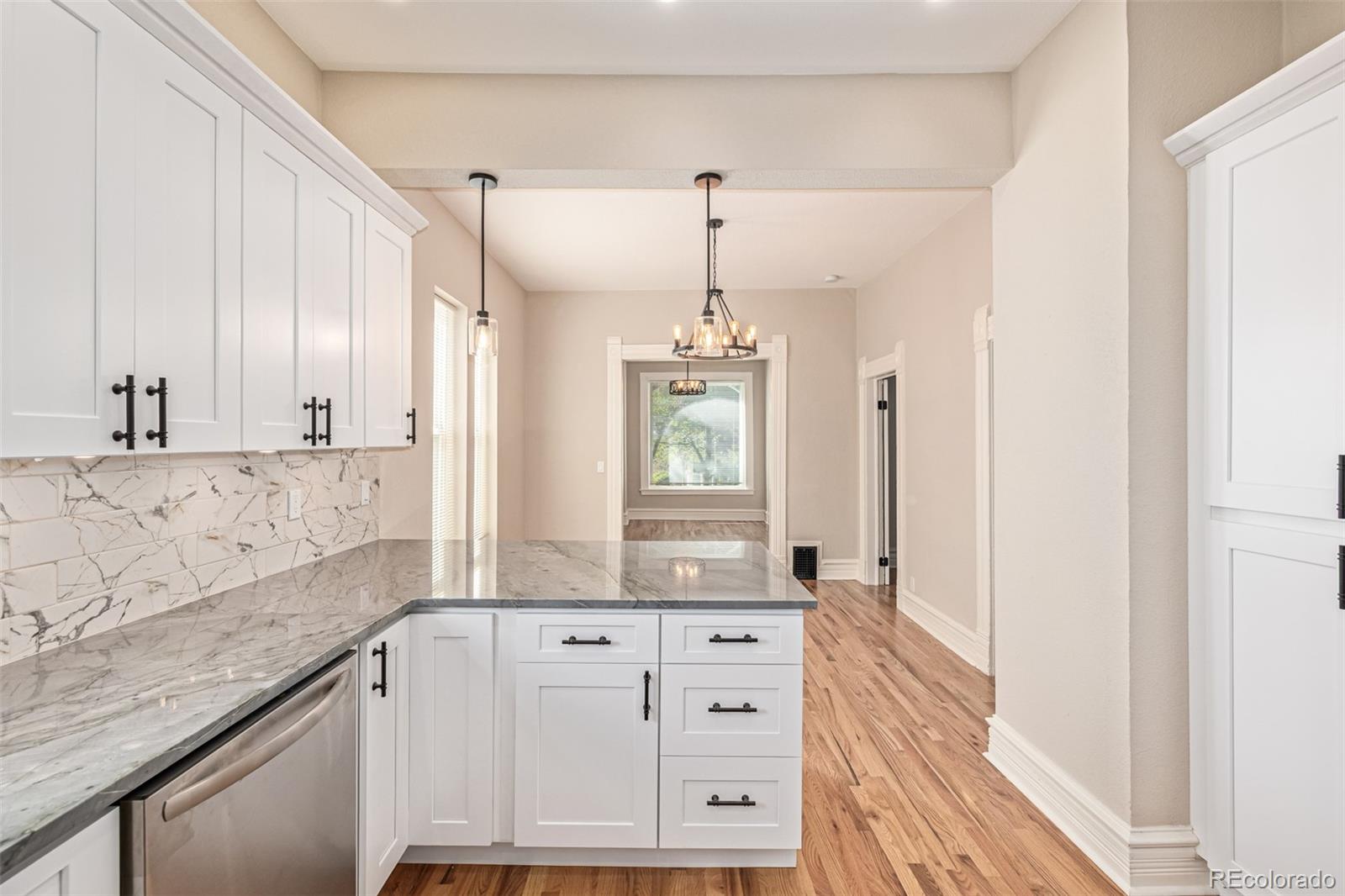 3854 Cook Street Denver, CO 80205 - Photo 14 of 42 a bathroom with a granite countertop sink a mirror and a shower