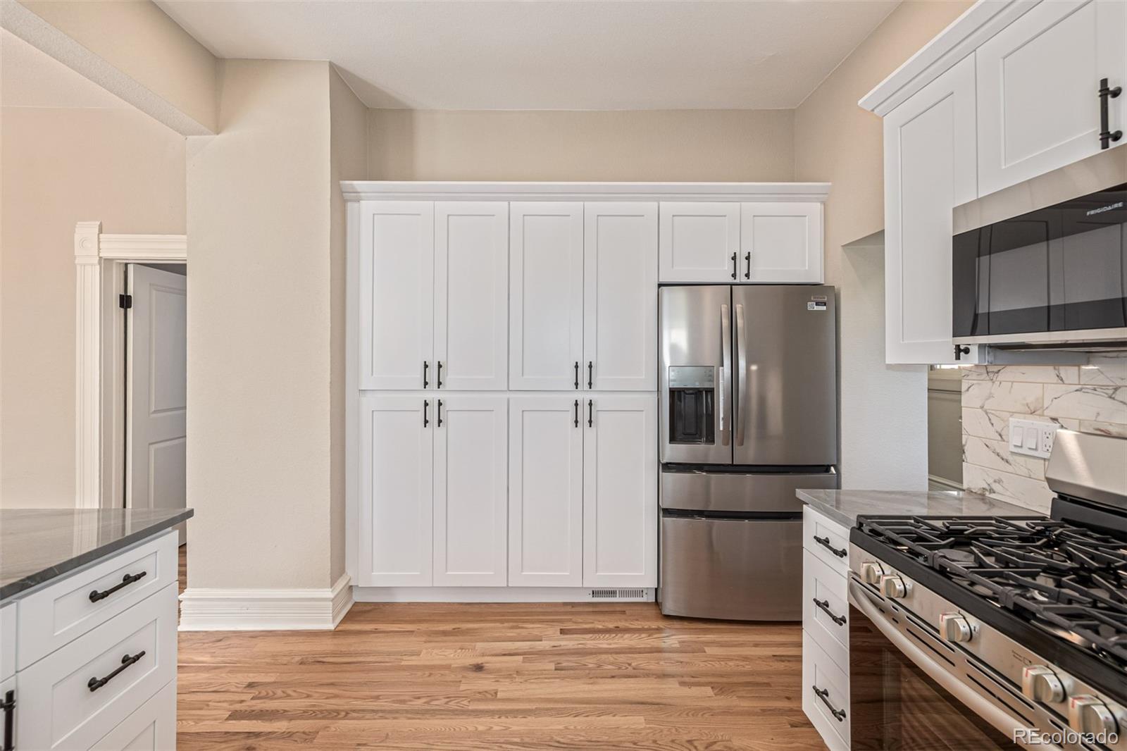 3854 Cook Street Denver, CO 80205 - Photo 15 of 42 a kitchen with a refrigerator stove and wooden cabinets
