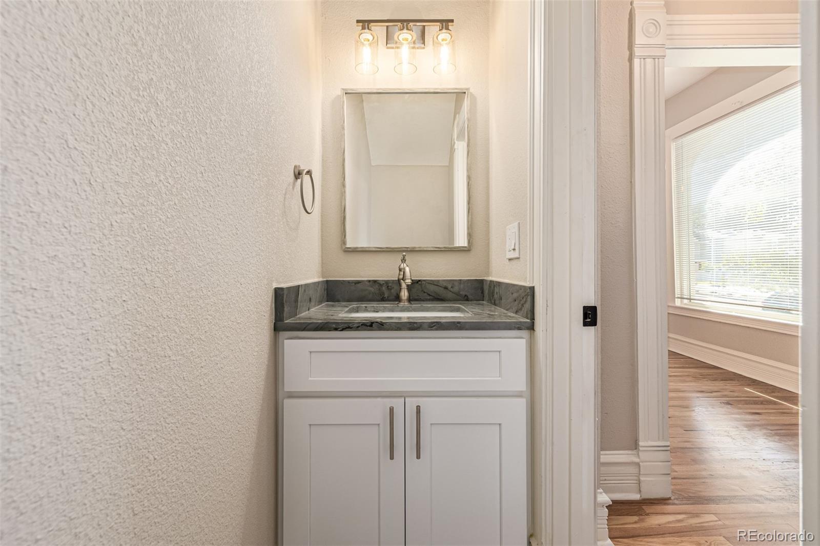 3854 Cook Street Denver, CO 80205 - Photo 16 of 42 a bathroom with a granite countertop sink and a mirror