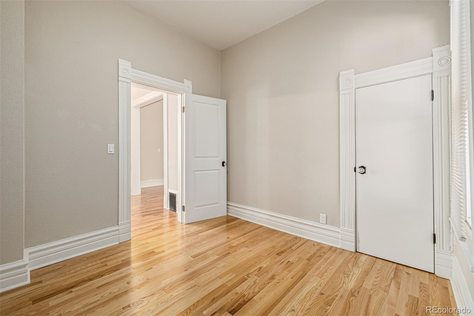 3854 Cook Street Denver, CO 80205 - Photo 18 of 42 an empty room with wooden floor and entrance
