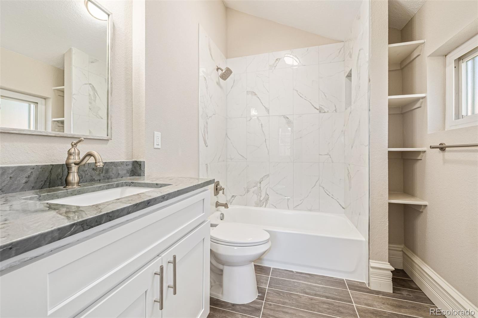 3854 Cook Street Denver, CO 80205 - Photo 29 of 42 a bathroom with a granite countertop sink toilet and shower