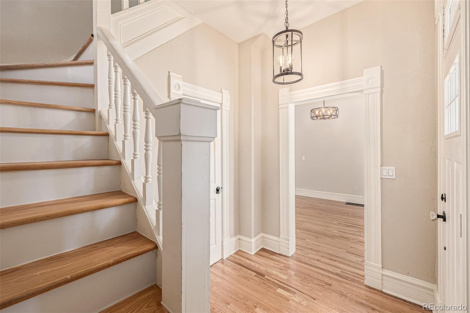 3854 Cook Street Denver, CO 80205 - Photo 3 of 42 a view of a hallway with wooden floor and staircase